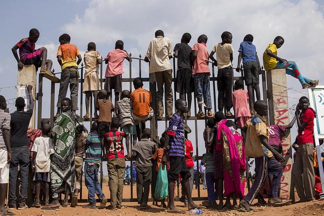 Internally displaced South Sudanese children climb a gate in Juba. Credit: UN Photo/JC McIlwaine.