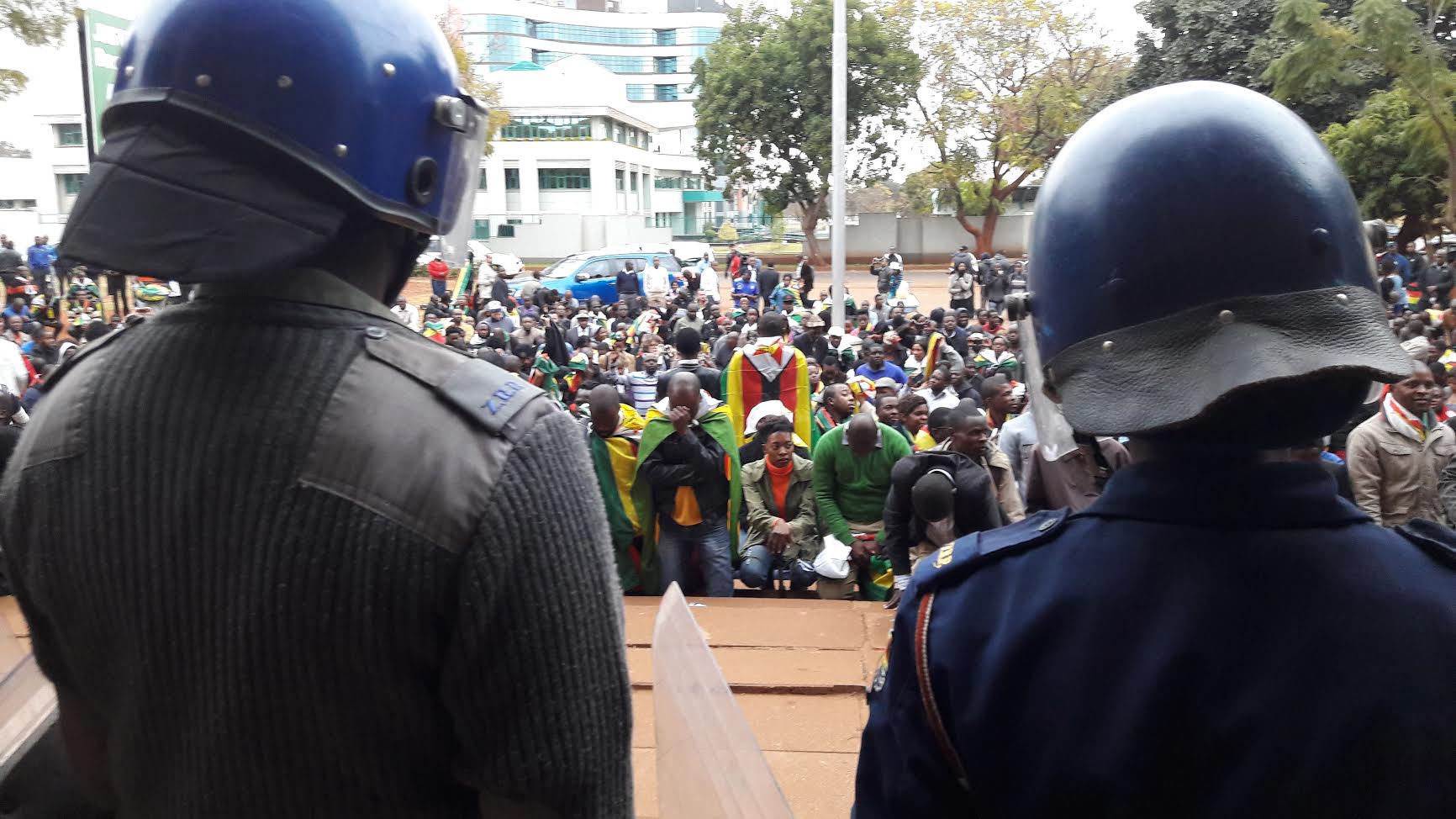 Zimbabwean police watch as protesters gather outside the court. Credit: Simon Allison.