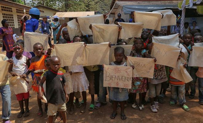 Children in the capital Bangui hold up signs reading "Peace" and "Love". Credit: UN Photo/Nektarios Markogiannis.