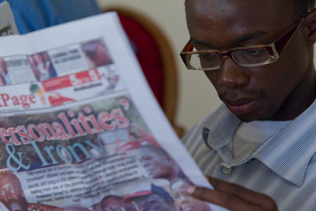 Reading a newspaper in Liberia. Credit: Together Liberia.