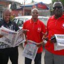 Ansbert Ngurumo (left) reads one of the newspapers he previously edited. Credit: John Dande.