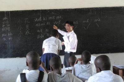 A Chinese teacher giving a lesson to young Tanzanian students. Credit: Claire van den Heever.