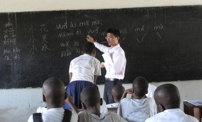 A Chinese teacher giving a lesson to young Tanzanian students. Credit: Claire van den Heever.