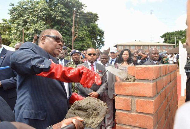 President Peter Mutharika lays a brick as Vice-President Saulos Chilima (in the sunglasses) watches on. Arthur Peter Mutharika
