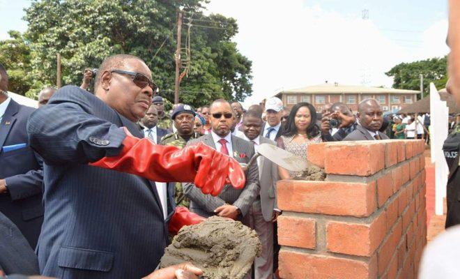 President Peter Mutharika lays a brick as Vice-President Saulos Chilima (in the sunglasses) watches on. Arthur Peter Mutharika