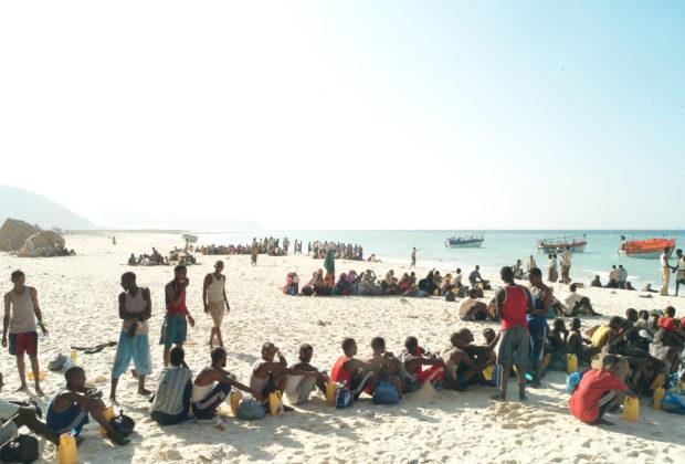Refugees and migrants line up on a Somalia beach to board the boats that will take them across the Gulf of Aden to Yemen. In a military style operation, the passengers board the small smugglers’ boats in groups of 10. The overcrowded boats can take days to cross. Credit: Alixandra Fazzina.