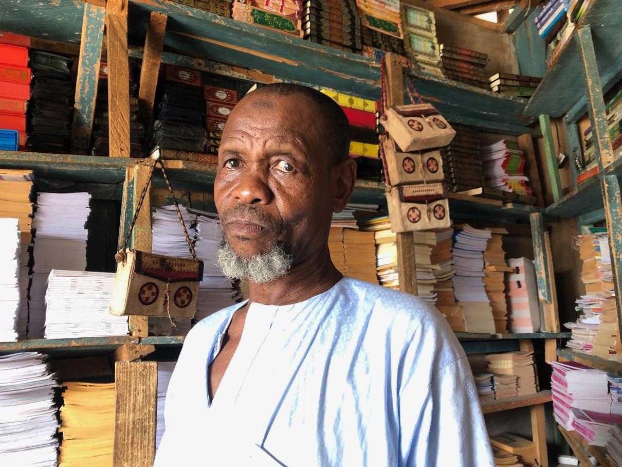 Ibrahim Garki standing in his book shop. Credit: Obi Anyadike.