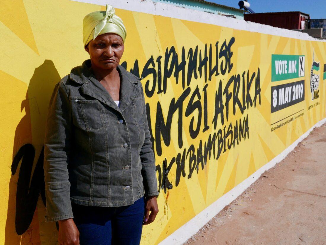 Nontwazana Ruselo, standing in front of an ANC mural in Zwide township. Credit: Martin Plaut.