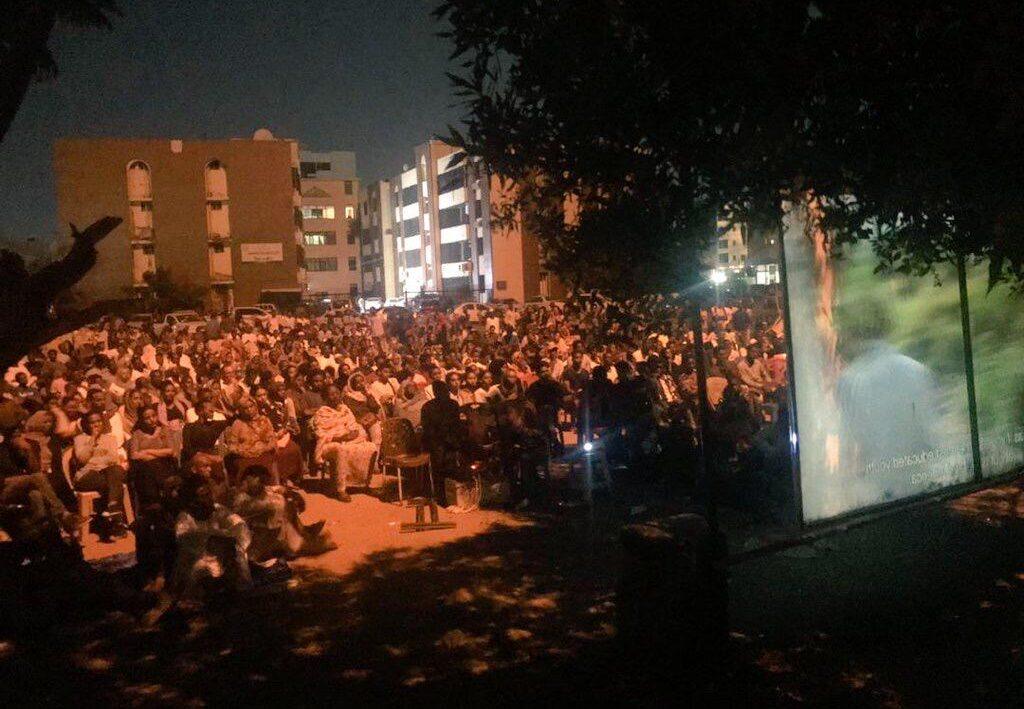 Les gens se rassemblent pour une projection de film en plein air à Khartoum, au Soudan. 