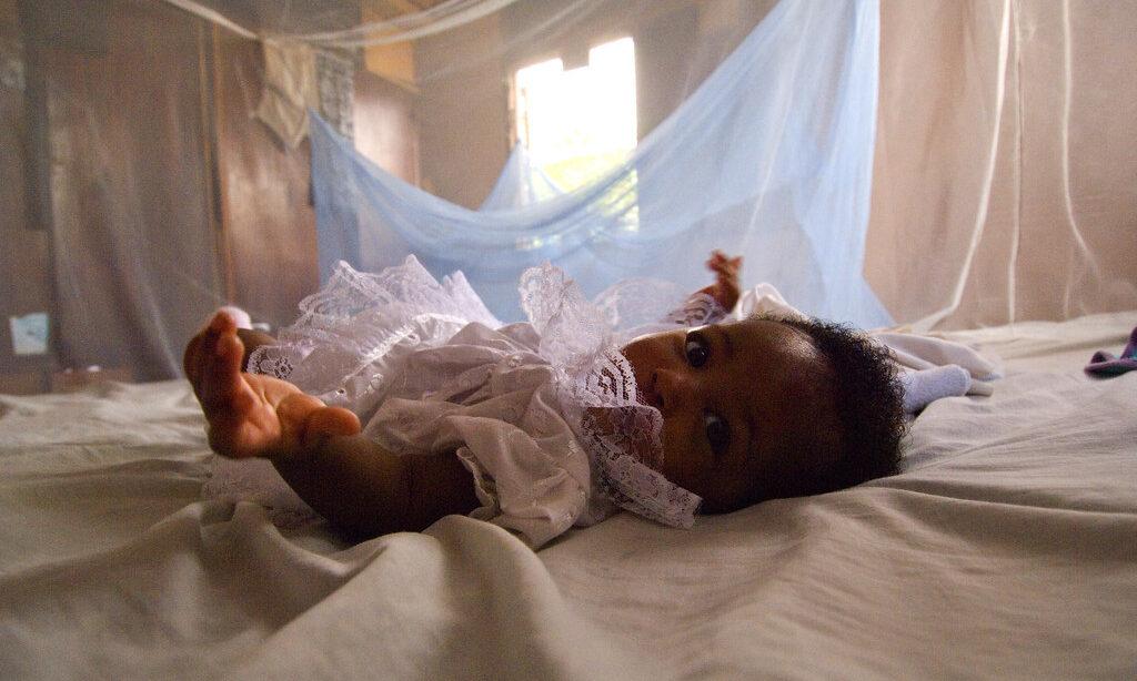An infant surrounded by malaria bed net in Ghana. Credit: Arne Hoel / World Bank.