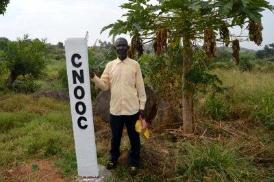 east africa pipeline Okecha Cibojo, a farmer in Nyamtai village, Kikuube District in Western region of Uganda standing by CNOOC beacons marking the route of a feeder pipeline for Kingfisher project. Credit: Maina Waruru.