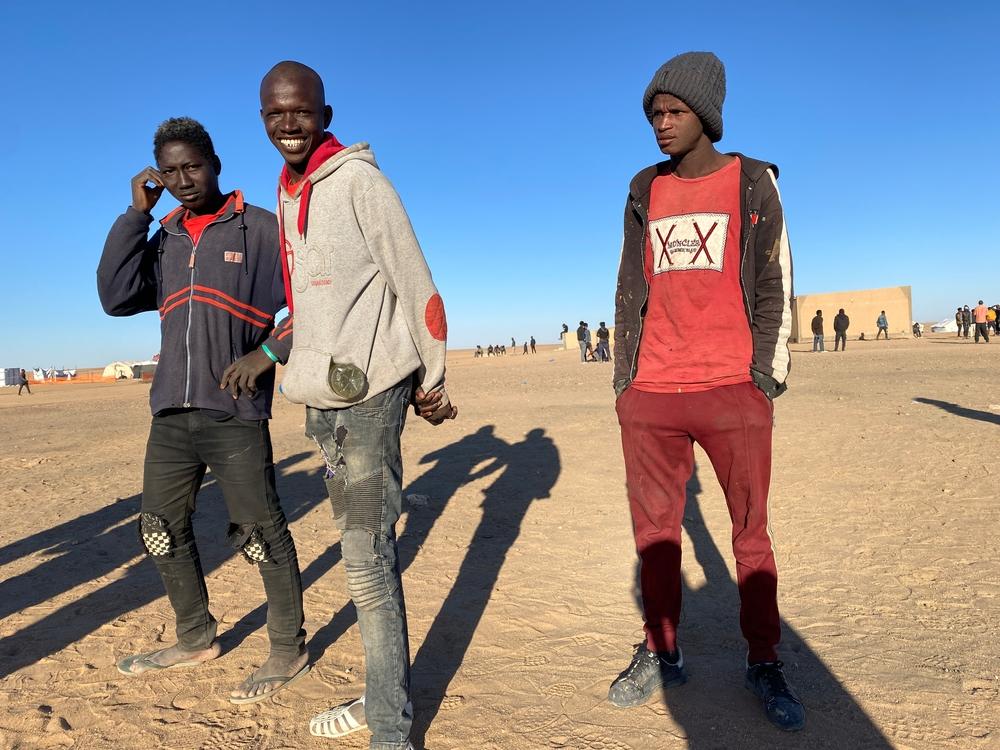 Three young men joke with each other to pass the time near the reception site in Assamaka, Niger, soon after being deported from Algeria. Because of COVID-19, all recently returned migrants are held here for a quarantine period of 14 days before being transported to Agadez. Credit: Mariama Diallo/MSF.
