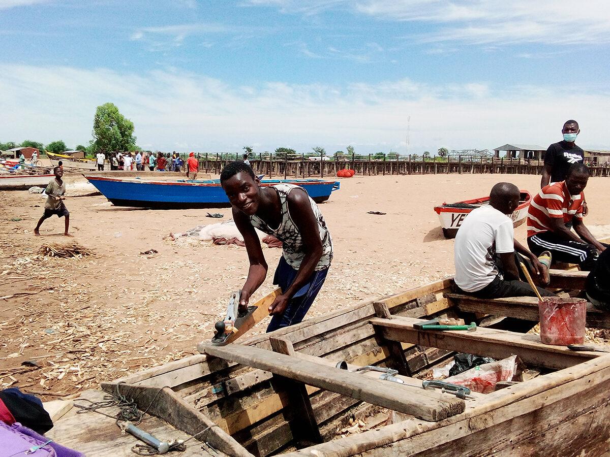 Fixing boats on Chikombe beach before the journey. Credit: Charles Pensulo.