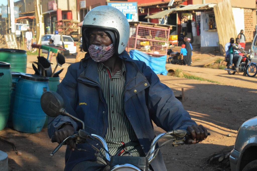 Nassur Sebakali, a boda boda driver, waits for customers in Kiwanga village in late August. The national lockdown severely impacted his business and made it difficult to support his family. Credit: Beatrice Lamwaka/Global Press Journal.