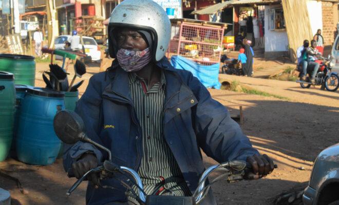 Nassur Sebakali, a boda boda driver, waits for customers in Kiwanga village in late August. The national lockdown severely impacted his business and made it difficult to support his family. Credit: Beatrice Lamwaka/Global Press Journal.