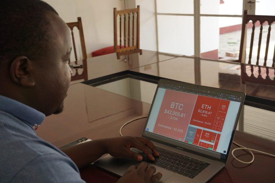 Confidence Nyirenda monitors cryptocurrency prices from his laptop. The 27-year-old computer science graduate runs a cryptocurrency exchange service in Zimbabwe. Credit: Vimbai Chinembiri/Global Press Journal.