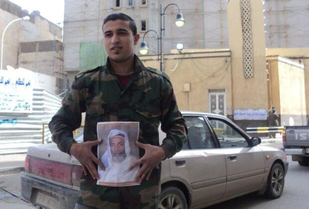 A man in Benghazi holds a picture of King Idris in the midst of the Libyan Uprising in 2011. Credit: Maher27777