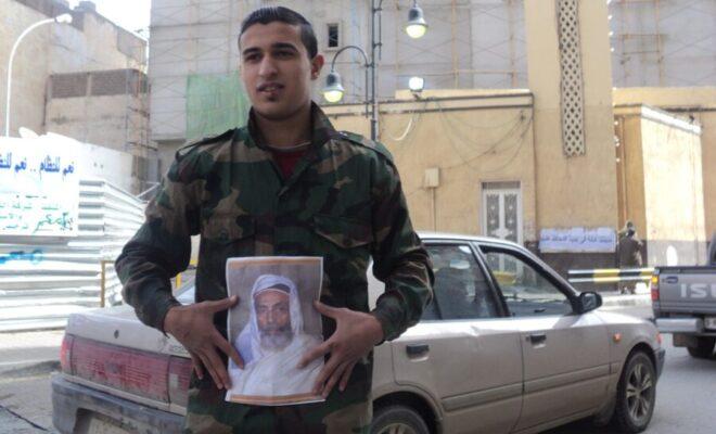 A man in Benghazi holds a picture of King Idris in the midst of the Libyan Uprising in 2011. Credit: Maher27777