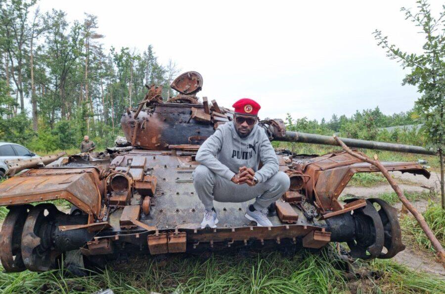 Bobi Wine poses on a destroyed Russian tank in Bucha. Credit: HEBobiWine.