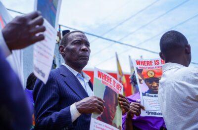 A man holds an image one of the individuals who disappeared and is still missing at a rally in Uganda. Credit: NUP.