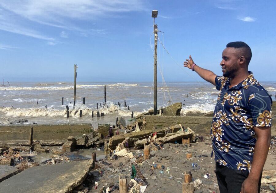 Akingboye Thompson points to the left by the ravaging Atlantic Ocean. Credit: Abiodun Jamiu.