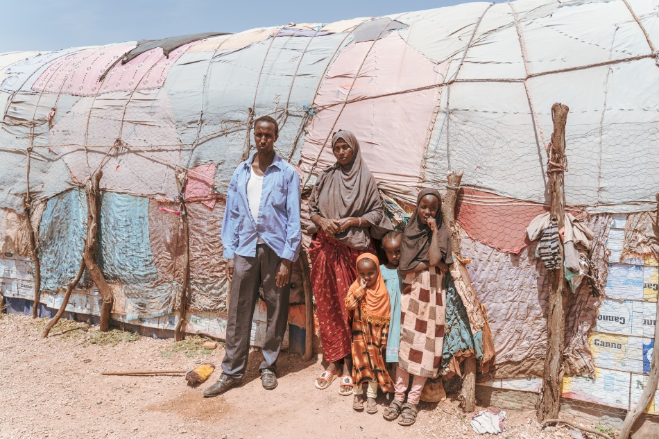 Khader Daheir Muhammad Egal stands with his family outside their makeshift home in Wado-Baris, Somaliland, where they settled after being displaced by drought. Credit: Jaclynn Ashly.