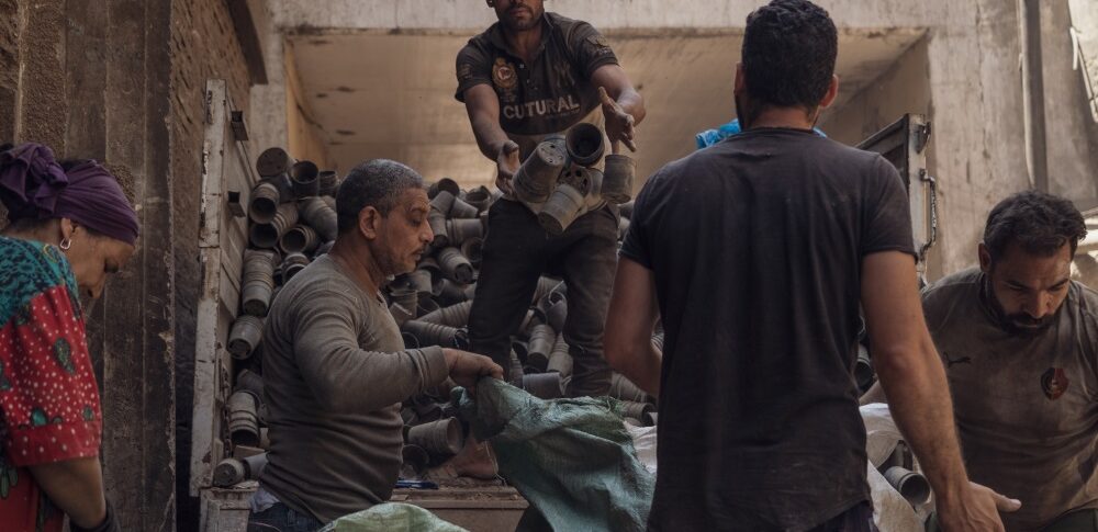 Sheata Abu Diem and his family, all members of the Zabbaleen in Cairo, unloading plastic flower pots for recycling. Credit: Jaclynn Ashly.